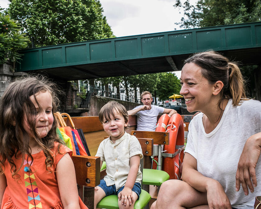 Una familia con dos niños sentada en un barco durante un paseo por el centro de Gante