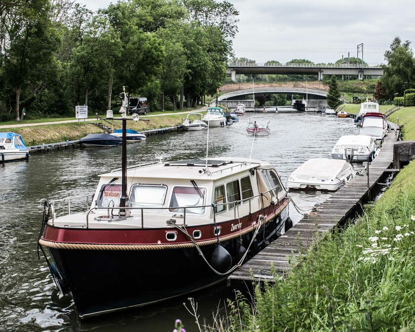 El río Lys en las afueras de la ciudad con varios barcos privados atracados en ambas orillas