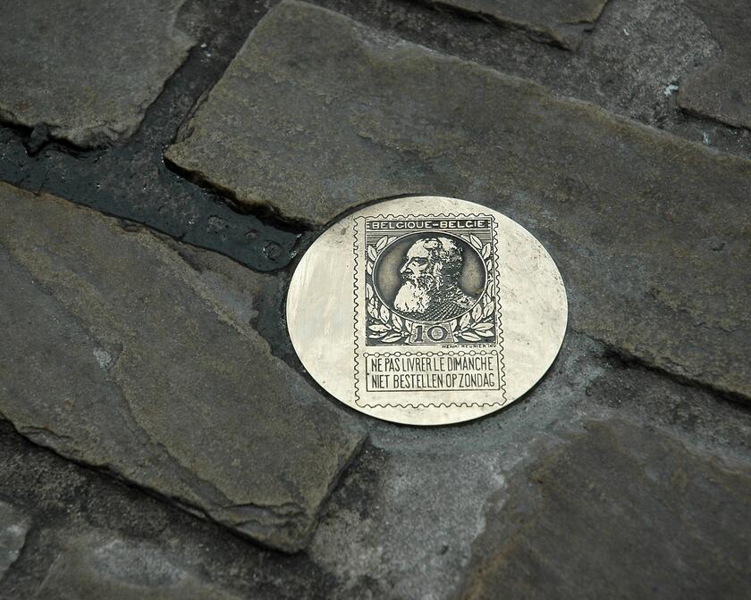 Close-up van een muntje van de muntroute op straat.