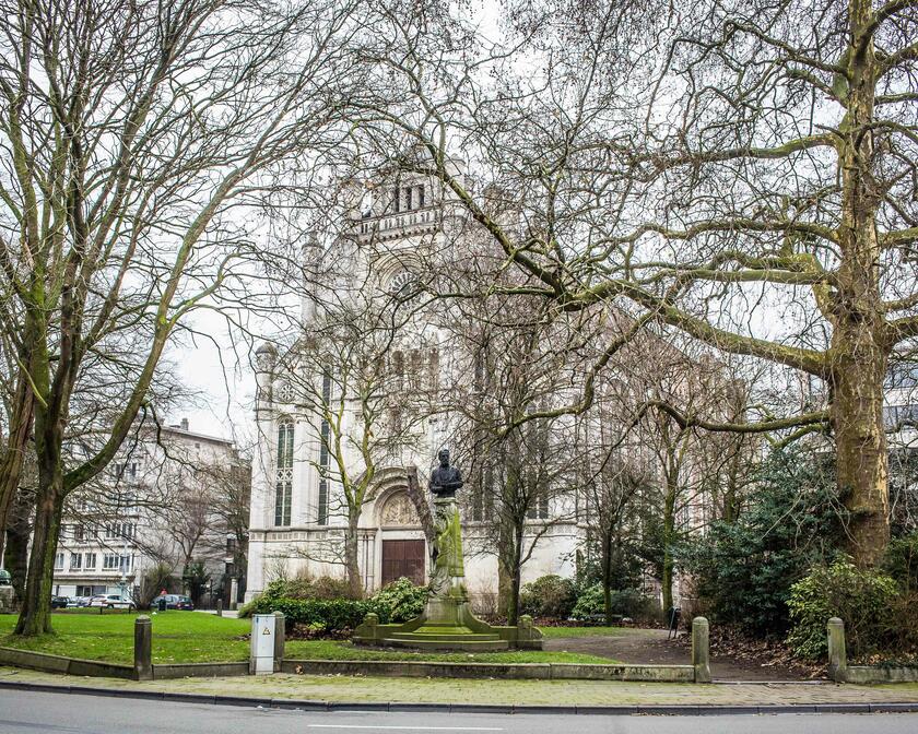 Sint-Annakerk met op de voorgrond het park van het Sint-Annaplein met winterse bomen en een standbeeld.