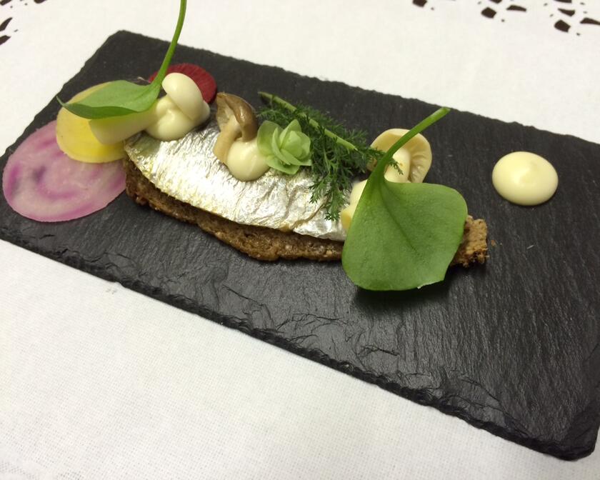 makreel met toast en champignons op een leisteen geserveerd