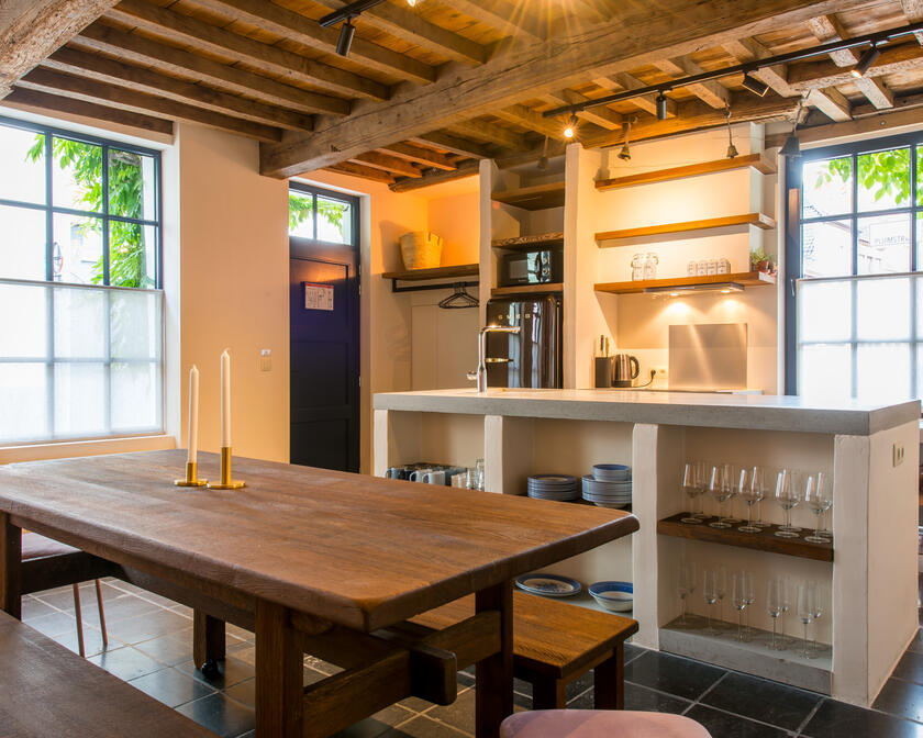 grote, open keuken met houten tafel en houten plafondgewelf 