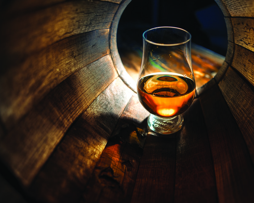 Glass of whisky in a barrel