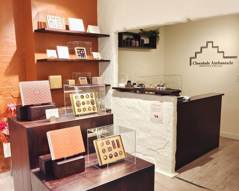 The interior of the shop with several open gold gift boxes with chocolates 