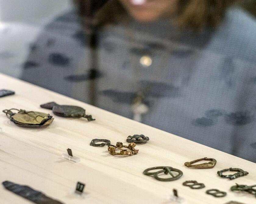 Woman looks at metal jewellery
