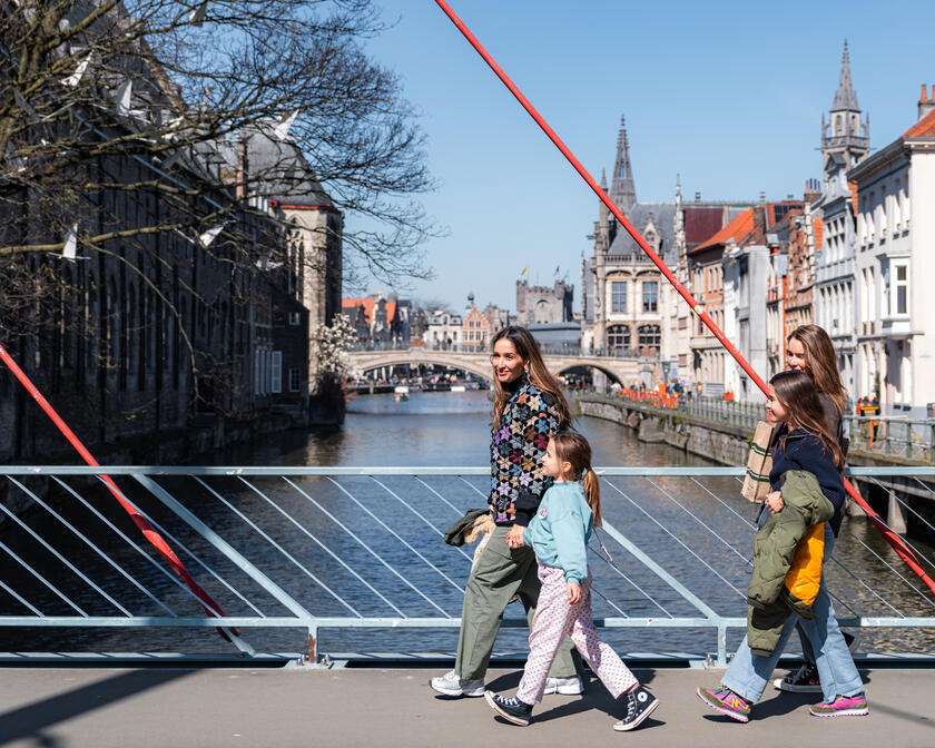 Tiany Kiriloff und ihre drei Töchter gehen an einem sonnigen Tag über eine Brücke an der Uferpromenade in Gent