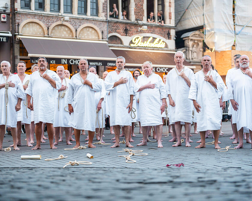 Mannen in wit gewaad met strop rond hun nek tijdens de stroppenstoet van de Gentse Feesten