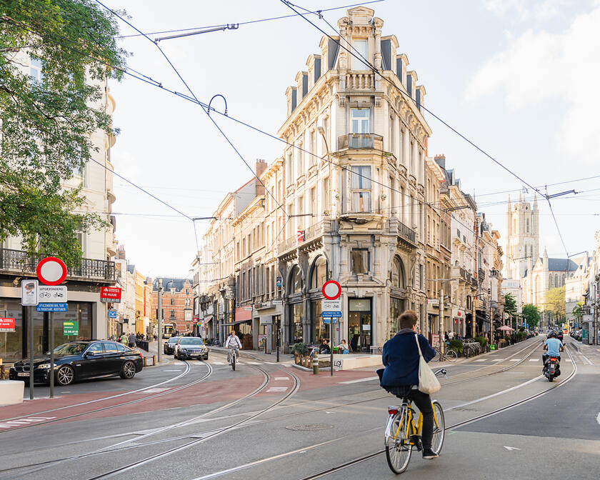 Menschen auf einem Fahrrad und einem Moped im Stadtzentrum