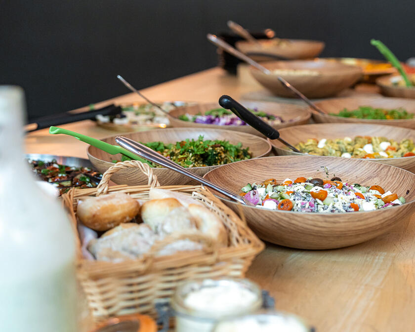 Several bowls of colourful salads on wooden table