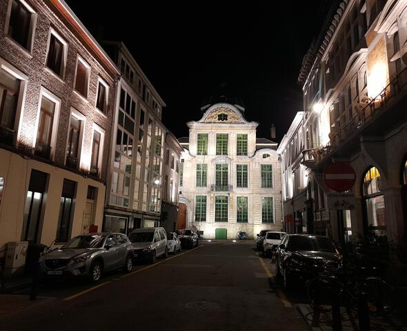 Fachada iluminada de la Real Academia de Lengua y Literatura Neerlandesa en Koningstraat por la noche