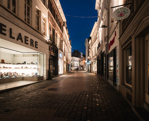 Beleuchtete Schaufenster der Geschäfte in der Koestraat in Gent in der Abenddämmerung