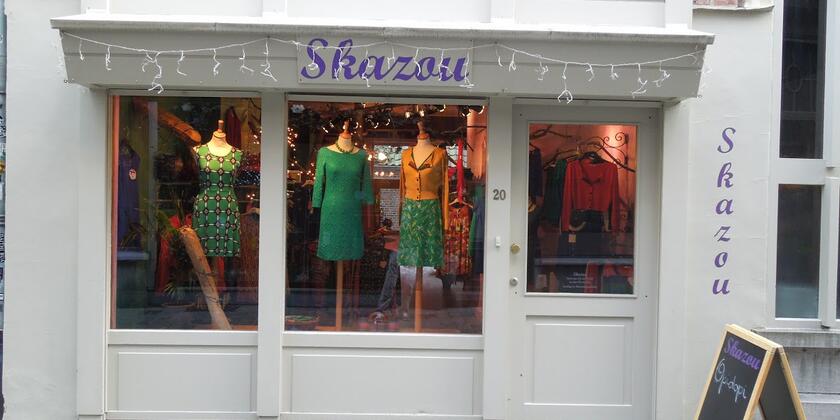 Etalage van kledingwinkel met etalagepoppen in kleurrijke rokken en jurken