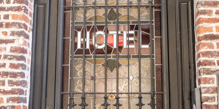 Glas-in-loodraam met het woord 'hotel'.