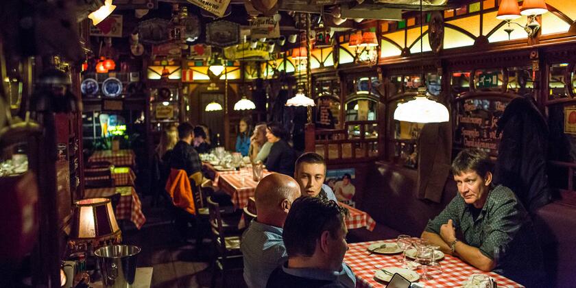 Volks restaurant voor 'ribbekes', met bierpullen aan het plafond, rood-wit geblokte tafellakens.