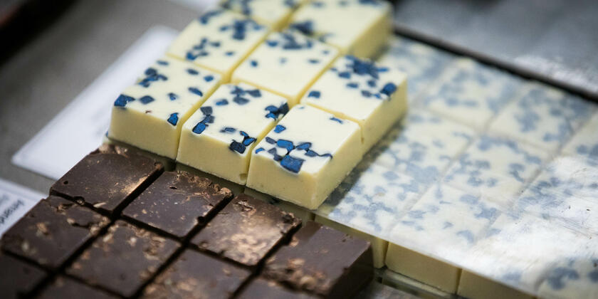 Close-up van pralines in de etalage, pure chocolade pralines en witte met blauwe stippen pralines.