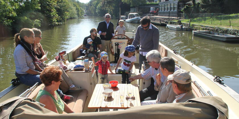 Familie met kinderen op een boot op de Leie buiten de stad