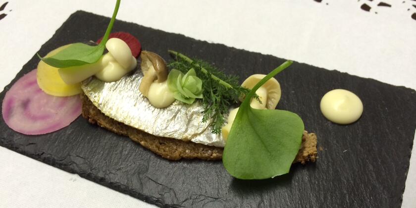 makreel met toast en champignons op een leisteen geserveerd