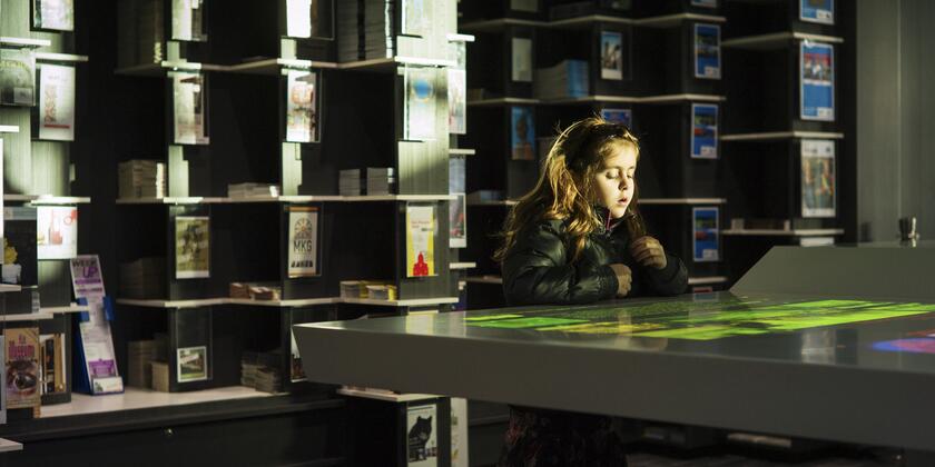 Meisje bekijkt datatafel in het toeristisch infokantoor 