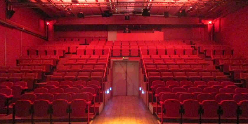 auditorium met rode verlichting en rode klapstoelen