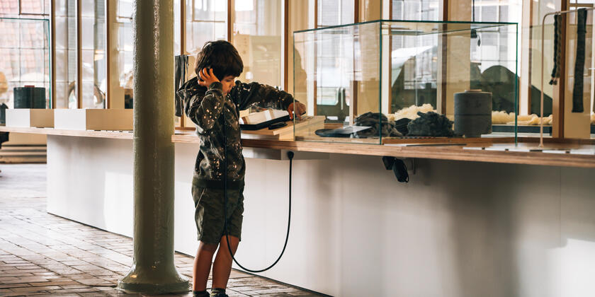 jongen luistert aandachtig naar de info in het industriemuseum