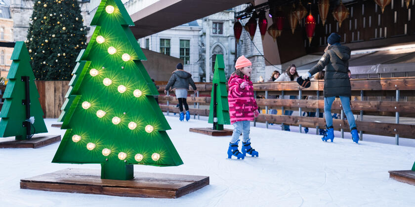 Kind aan het schaatsen op de ijspiste onder de Stadshal