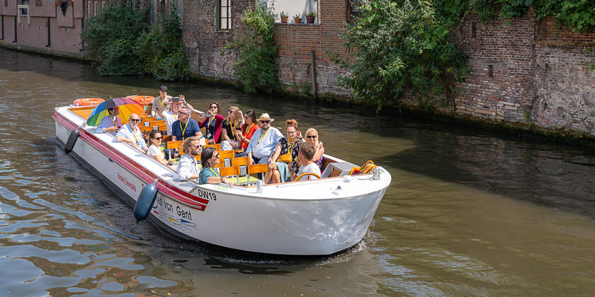 Congresdeelnemers in wit bootje op de binnenwateren van Gent