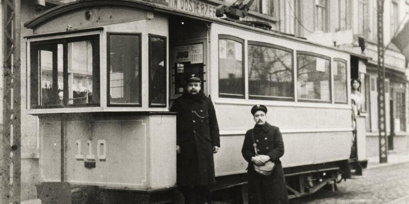 Ein Schaffner und ein Empfänger posieren vor ihrem zweiachsigen Fahrzeug auf der Linie 2 (Muide, Zuid, Ledeberg), 1913. Fotograf unbekannt.