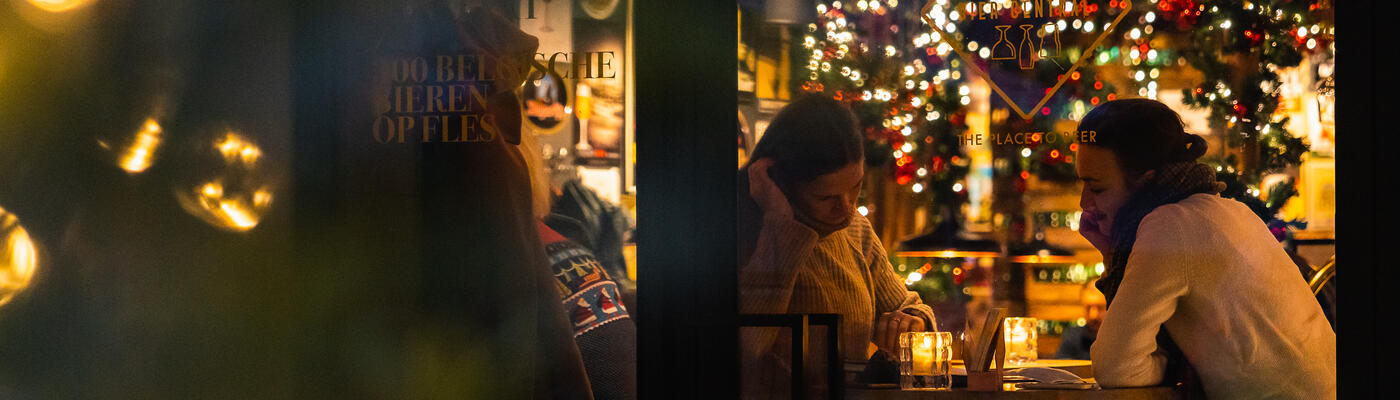 Couple à une table avec des lumières de Noël à la fenêtre