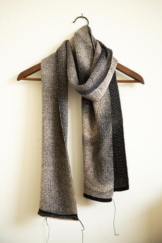 Sjaal in grijstinten hangt aan kleerhanger