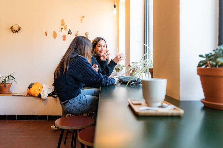 Tiany Kiriloff und ihre Tochter genießen einen Kaffee vor dem Fenster einer gemütlichen Kaffeebar in Gent