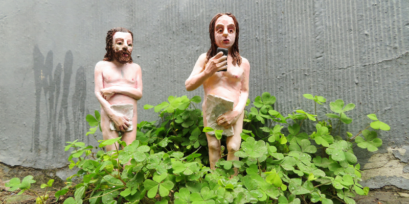 Beeldjes van Adam en Eva op een voetpad in Gent