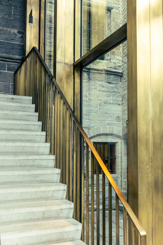 Concrete staircase with brass handrail shows visitors the way in St Bavo Cathedral's new visitor centre