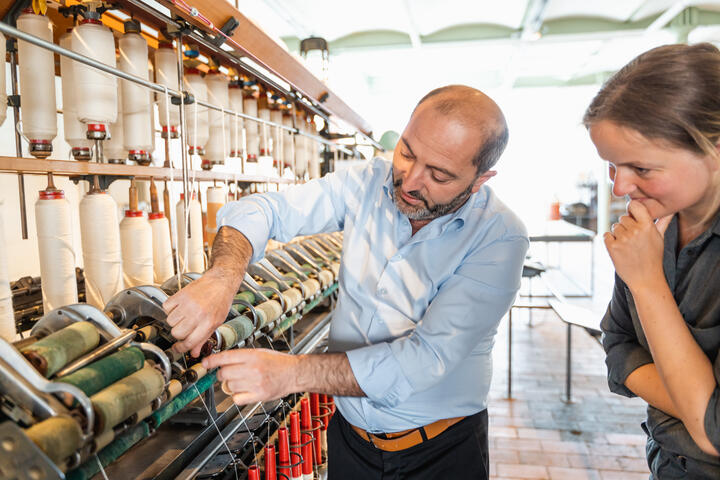 L'homme montre l'effet de la machine textile dans le Musée de l'Industrie de Gand
