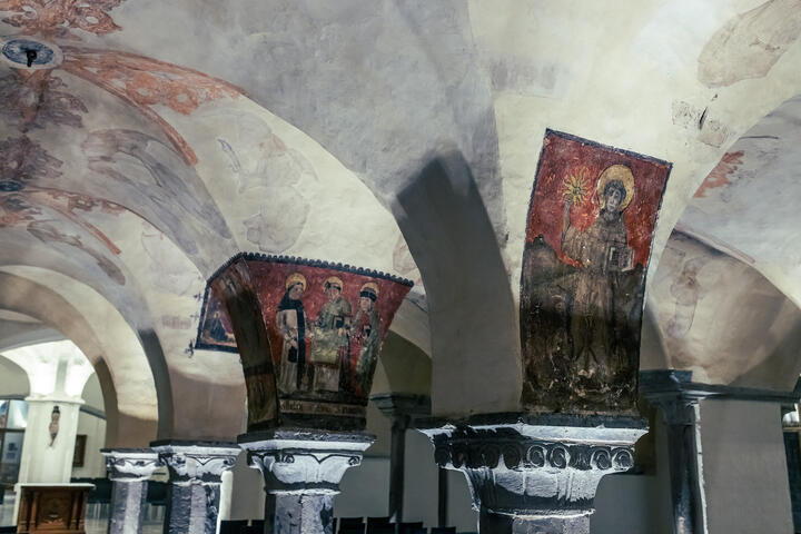 Romanische dunkelrote Fresken an den Säulen der Krypta der St.-Bavo-Kathedrale