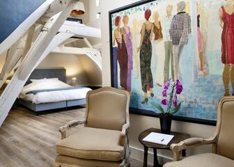 Lounge met makkelijke armstoelen, beschilderde muur met kleurrijke menselijke figuren.