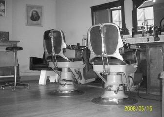 Oude foto van twee kappersstoelen.