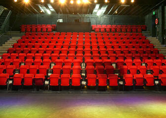 De theaterzaal met rode stoelen van het Arcatheater.