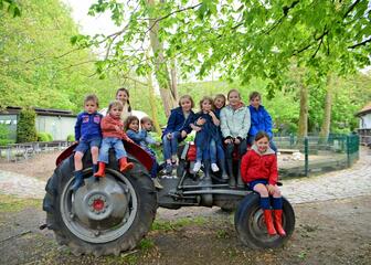 Schoolkindjes op tractor van de kinderboerderij