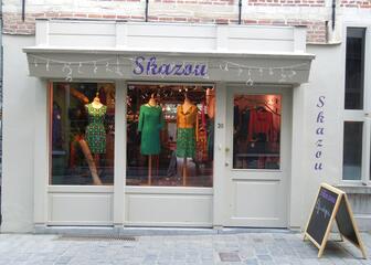 Etalage van kledingwinkel met etalagepoppen in kleurrijke rokken en jurken