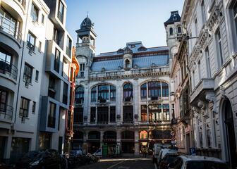Photo du Vooruit à Gand, un grand bâtiment de style Art nouveau. Sur la façade, on peut lire "feestlokaal van vooruit" (Salle de fêtes du Vooruit).