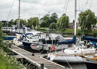 Local harbour on the river Lys with boats docked on both sides of the river