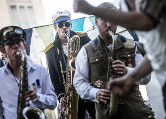 3 jonge muzikanten blazen op hun koperen saxofoons op Jazz in het Park