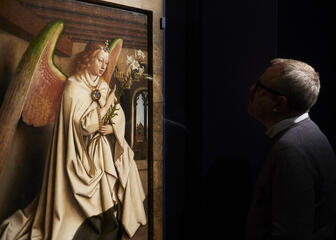 een man die naar een schilderij van de engel gabriël kijkt
