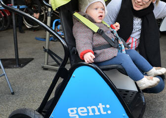 Mama met kind in buggy van Gent aan het fietspunt.