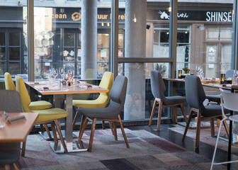 Restaurant met comfortabele stoelen in grijs en geel.