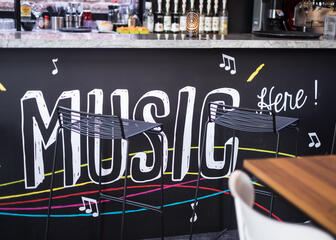 Cocktailbar met daarop een grote tekening met "muziek hier".