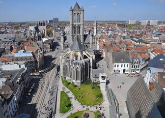 Luchtfoto van Sint-Niklaaskerk en stadsparkje met groen grasveld, veel voetgangers.