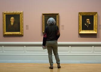 Bezoeker die kijkt naar enkele schilderijen in het Museum voor Schone Kunsten.