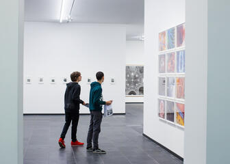 Twee jongens bewonderen eigentijdse kunst in de galerij.
