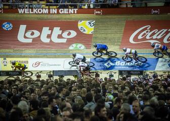 Vijf wielrenners op de Gentse wielerpiste 't Kuipke tijdens de Zesdaagse van Gent. Het middenplein staat vol met toeschouwers. 